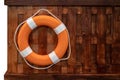 Lifebuoy Ring hanging on wooden wall panel and carpet floor. Royalty Free Stock Photo
