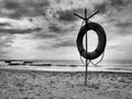 Lifebuoy on a sandy beach. Orange circle on a pole to rescue people drowning in the sea. Rescue point on the shore. Sky Royalty Free Stock Photo