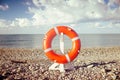 Lifebuoy, sea and stones beach. Symbol of safety and travel Royalty Free Stock Photo