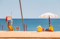 Lifeguard dressed in yellow sitting on a chair on the beach Royalty Free Stock Photo