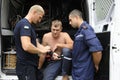 Lifeguard gets dive light on his hand standing in front of rescue mobile post, others watching