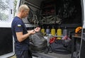 Lifeguard gets dive light on his hand standing in front of rescue mobile post, others watching