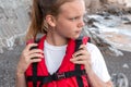 Lifeguard girl in red life jacket near sea. Concept of saving people in water. Rescuer on beach. Portrait of woman in life vest Royalty Free Stock Photo