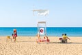 Lifeguard next to the tower on the beach sitting on a chair back Royalty Free Stock Photo