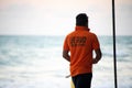 lifeguard in orange shirt carrying flag along the beach with tourists in background at havelock swaraj dweep andaman