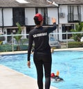 The lifeguard of a recreational pool gives safety instructions to swimmer.