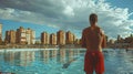 a lifeguard in red shorts, taking a momentary pause to gaze at the city skyline