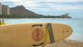 A lifeguard rescue surfboard at waikiki with diamond head in the distance