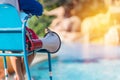 lifeguard sitting on chair with megaphone at poolside for guarding lives Royalty Free Stock Photo