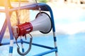 lifeguard sitting on chair with megaphone at poolside for guarding lives Royalty Free Stock Photo