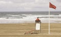 A lifeguard sitting on surveillance tower, front of the sea
