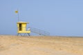 Lifeguard tower on the beach with yellow beach safety flag. Royalty Free Stock Photo