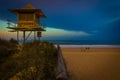 Lifeguard tower in grass near sand beach, sea and humans