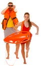 Lifeguards in life vest with rescue buoy running