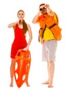 Lifeguards in life vest with rescue buoy whistling