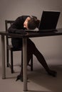 Lifeless woman in a black suit sitting on a table