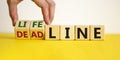 Lifeline or deadline symbol. Businessman turns wooden cubes and changes the word `deadline` to `lifeline` on a beautiful yello Royalty Free Stock Photo