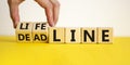 Lifeline or deadline symbol. Businessman turns wooden cubes and changes the word `deadline` to `lifeline` on a beautiful yello Royalty Free Stock Photo