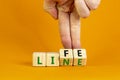 Lifeline, line of life symbol. Businessman hand turns cubes and changes the word `life` to `line`. Beautiful orange background Royalty Free Stock Photo