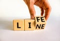Lifeline, line of life symbol. Businessman turns the wooden cube and changes the word Life to Line. Beautiful white table white Royalty Free Stock Photo