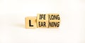 Lifelong learning symbol. Turned wooden cubes with concept words `Lifelong learning` on a beautiful white background. Copy space