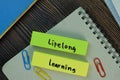 Lifelong learning write on sticky notes isolated on Wooden Table. Education concept