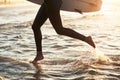 Lifes a beach. an unrecognizable young woman going surfing at the beach.