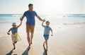 Lifes a hundred times better at the beach. a father bonding with his two little children at the beach.