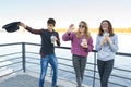 Lifestyle of adolescents, boy and two teen girls are walking in the city. Laughing, talking children eating street food, having Royalty Free Stock Photo