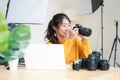 Lifestyle Asia young women photographer and freelance holding a dslr camera in home office.