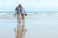 Lifestyle asian senior couple happy walking hug and relax on the beach. Tourism elderly family travel leisure and activity after