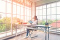 Lifestyle asian woman drinking hot coffee and reading book sitting on table near the window, so enjoying and relaxing at home Royalty Free Stock Photo