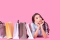 Lifestyle asian woman thinking shopping with many shopping bags while walking in the shopping mall.  Colorfull background Royalty Free Stock Photo