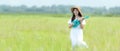 Lifestyle asian women white dress holding a guitar on a cloudy sunrise sky in the meadow flower, Royalty Free Stock Photo