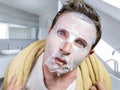 Young scared and surprised man at home using beauty paper facial mask cleansing doing anti aging facial treatment looking himself Royalty Free Stock Photo