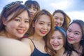 Lifestyle beach portrait of Asian Korean and Chinese women, group of happy beautiful young girlfriends taking selfie picture toget Royalty Free Stock Photo