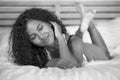 Lifestyle black and white portrait of young happy and gorgeous hispanic woman posing and playful at home bedroom lying relaxe