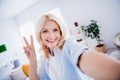 Lifestyle blogger selfie photographing mature aged lady makes v sign gesturing peace symbol businesswoman posing indoors