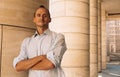 Young elegant handsome man dressed casual standing next to columns of an modern big building Royalty Free Stock Photo