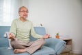 Lifestyle calm senior man lotus pose doing yoga for mental balance breathing air relaxing Royalty Free Stock Photo