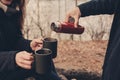 Lifestyle capture of couple drinking hot tea outdoor on cozy warm walk in forest Royalty Free Stock Photo