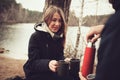 Lifestyle capture of couple drinking hot tea outdoor on cozy warm walk in forest Royalty Free Stock Photo