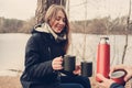 Lifestyle capture of couple drinking hot tea outdoor on cozy warm walk in forest Royalty Free Stock Photo