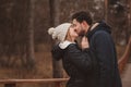 Lifestyle capture of happy couple kissing outdoor on cozy warm walk in forest Royalty Free Stock Photo