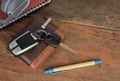 Key car and leather wallet on wooden table at office. Royalty Free Stock Photo