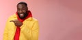 Charismatic carefree handsome black bearded guy in yellow jacket laughing friendly look camera chat pointing left show Royalty Free Stock Photo