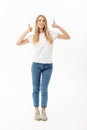 Lifestyle Concept: Happy smiling young woman in jeans looking at the camera giving a double thumbs up of success and Royalty Free Stock Photo