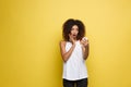 Lifestyle Concept - Portrait of beautiful African American woman shocking with something on mobile phone. Yellow pastel Royalty Free Stock Photo