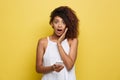 Lifestyle Concept - Portrait of beautiful African American woman shocking with something on mobile phone. Yellow pastel Royalty Free Stock Photo