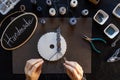 Lifestyle concept, reinvent your life and your job: flat lay top view of woman`s hands that knotting a macrame bracelet with tool